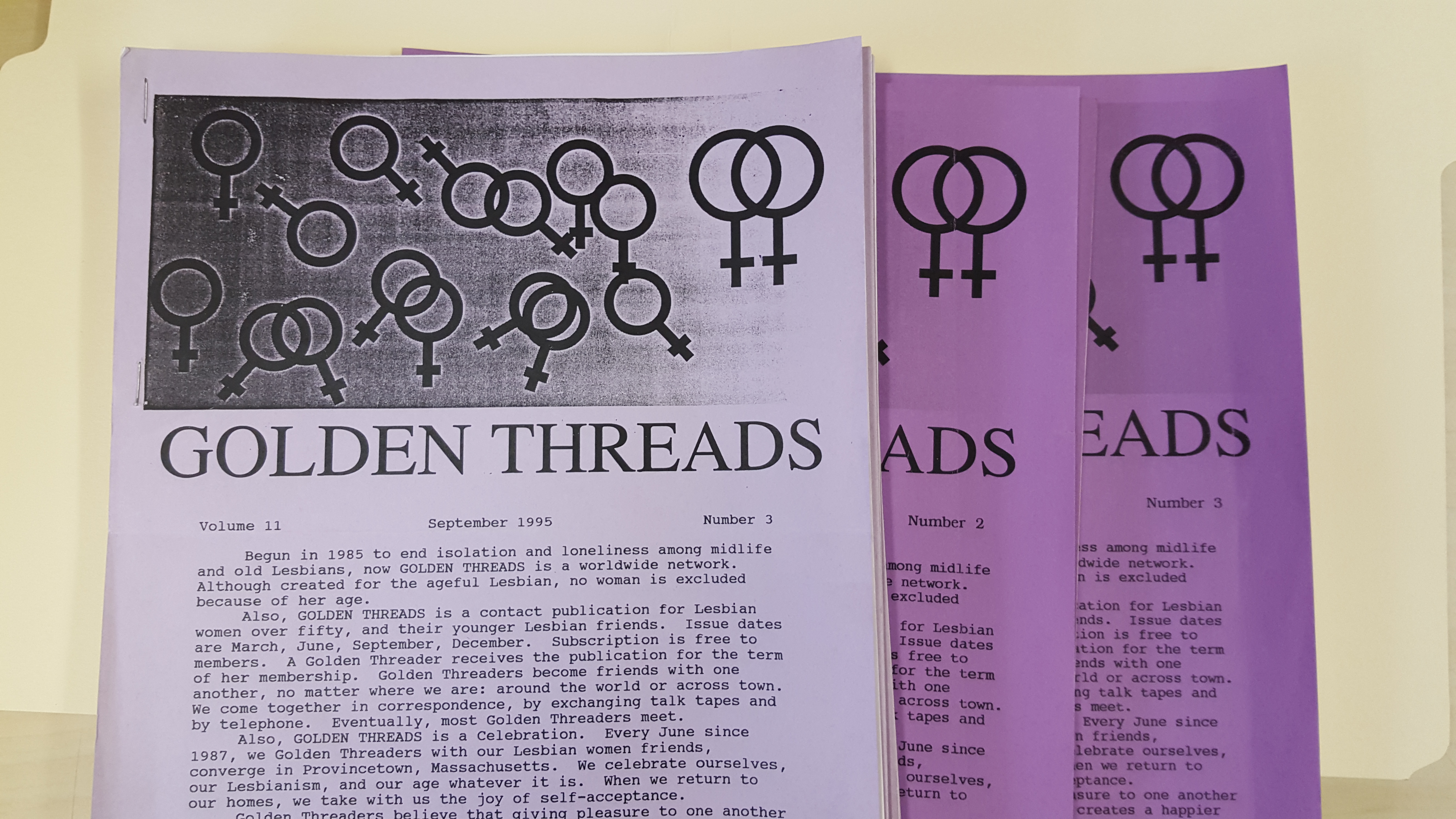 Three copies of a newsletter on lavender and purple paper with "Golden Threads" in large type.